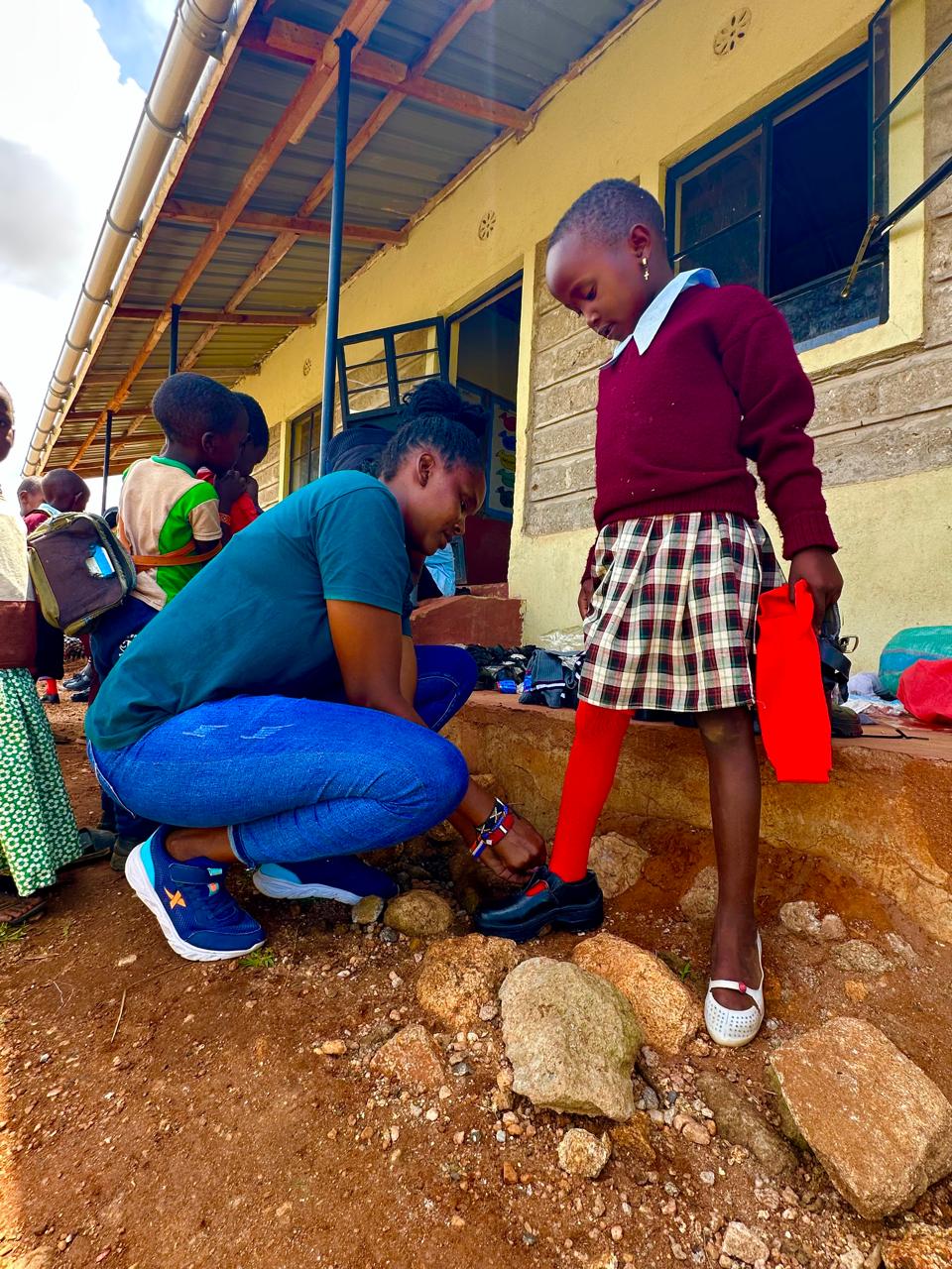 A young Maasai school girl receiving support with school shoes